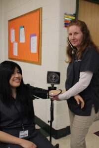 student checking another students blood pressure