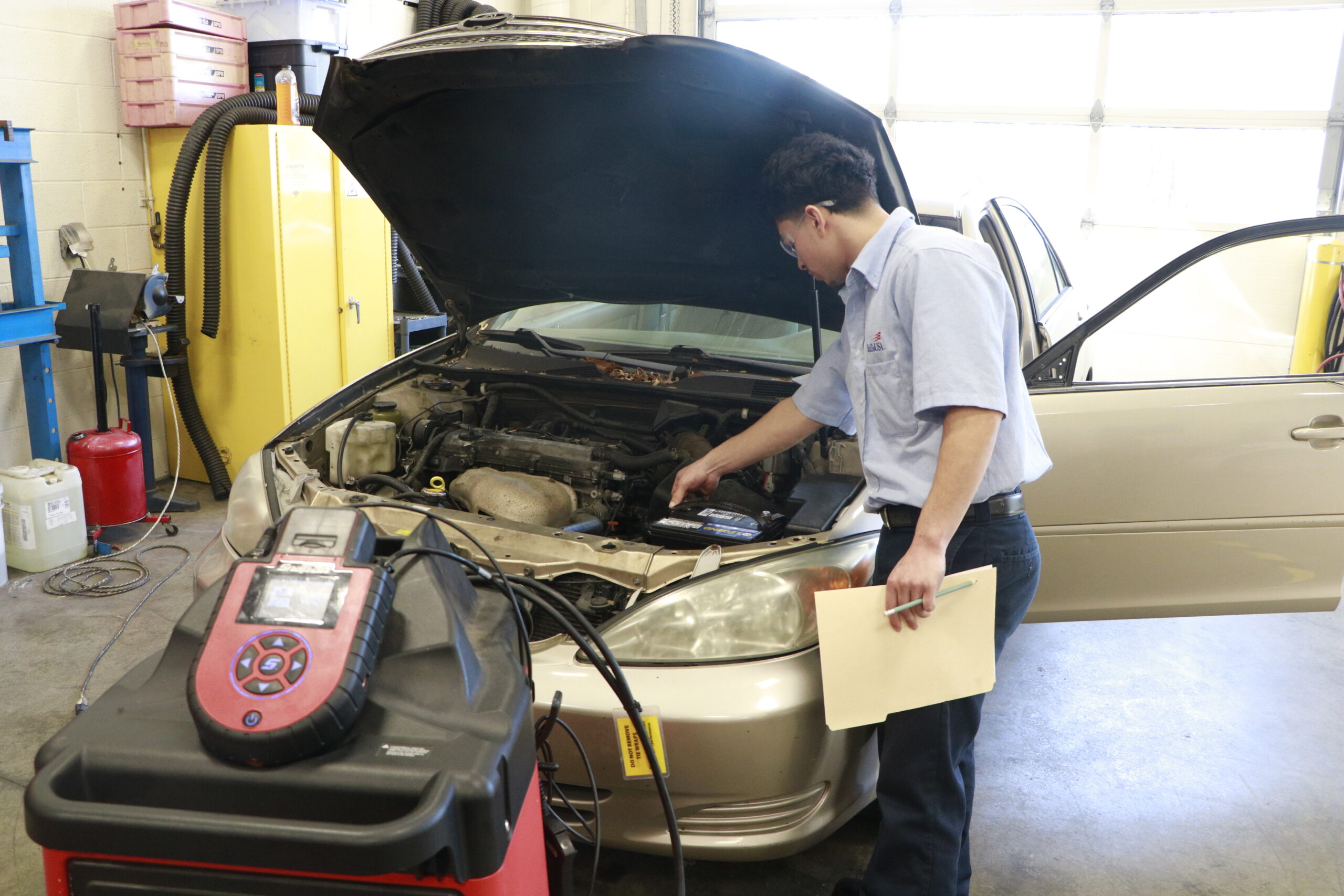 Student looking over hood of car
